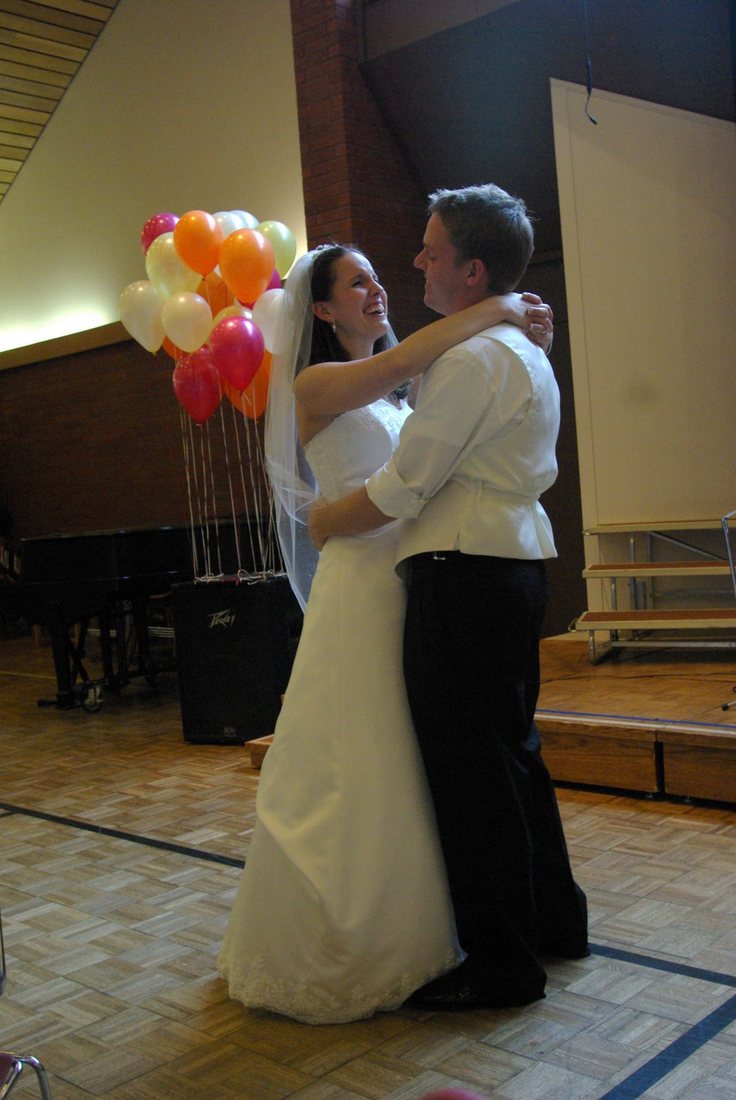 First dance in the fellowship hall, a cluster of balloons behind the couple