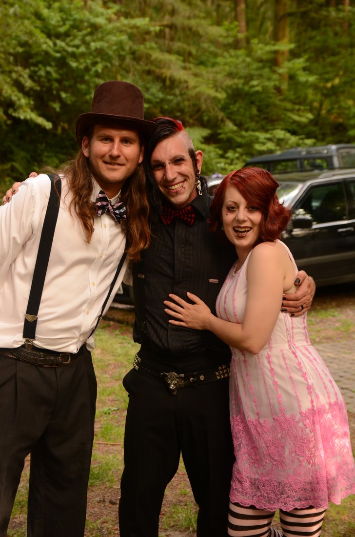 Three guests with arms around each other at the edge of the parking area