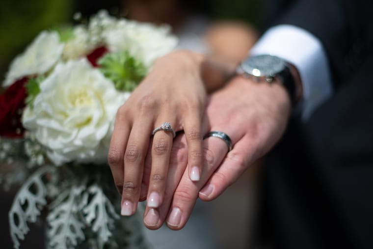 Bride and groom holding hands with rings and bouquet detail - Portland wedding photography